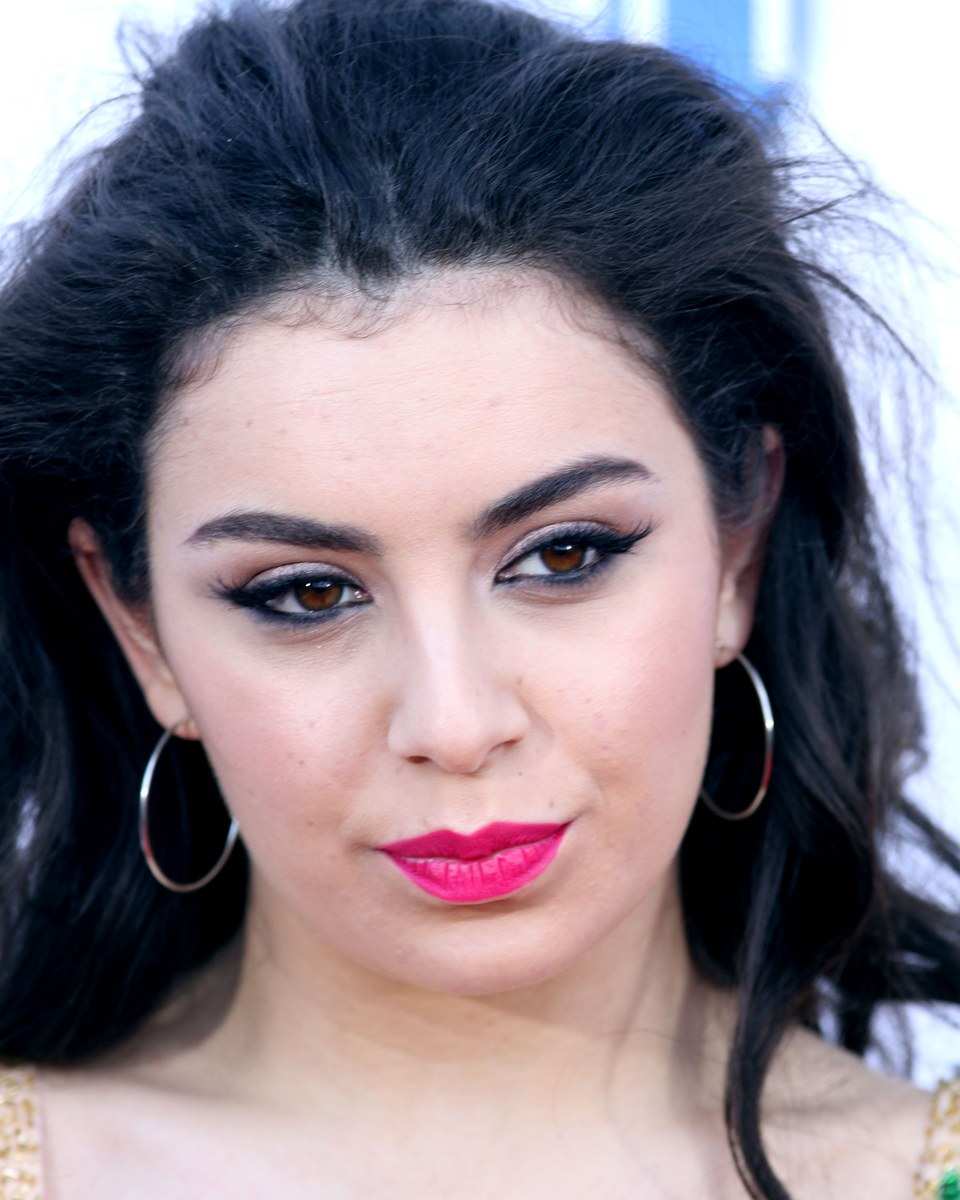Charli XCX with long dark hair and hoop earrings in 2014