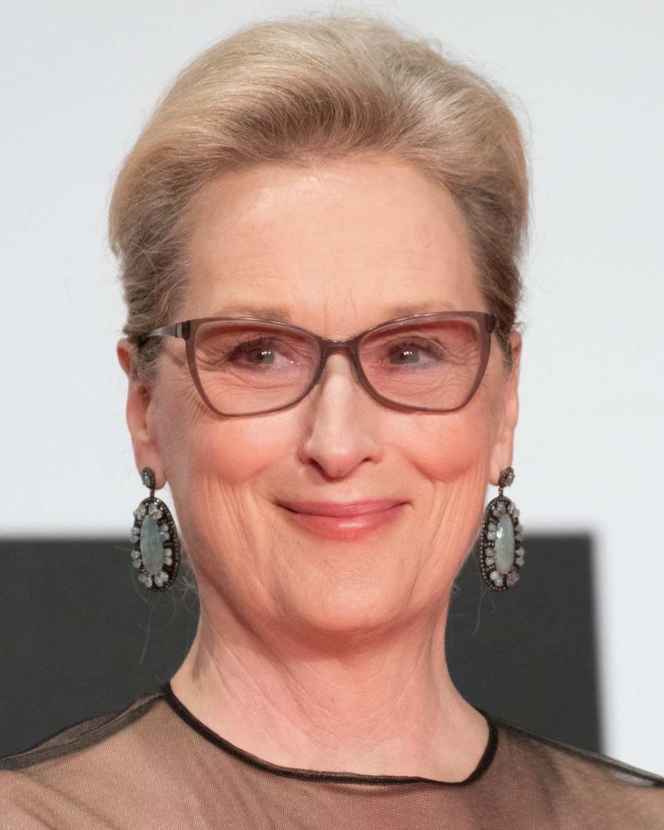 Meryl Streep smiling, in glasses and drop earrings, at the Tokyo International Film Festival in 2016